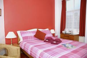 a bedroom with a bed with a purple plaid blanket at Adam Place Guest House in Windermere