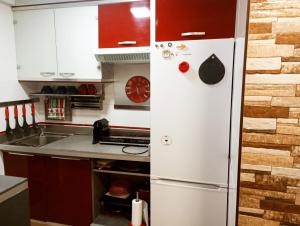 a kitchen with a white refrigerator in a kitchen at Precioso apartamento 3 habitaciones. Con patio. in Camas