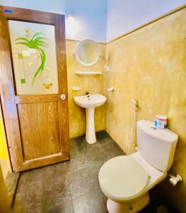 a bathroom with a toilet and a sink at Praneeth Guest House in Mirissa
