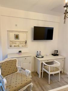 a living room with a desk and a tv on the wall at Pensiunea Charlotte Boutique in Bacău