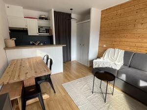 uma sala de estar com uma mesa e um sofá em Bel appartement rénové, central et skis aux pieds em Morzine