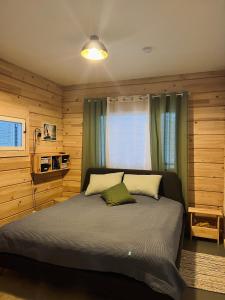 a bedroom with a large bed with wooden walls at Kiiski Home in Teijo