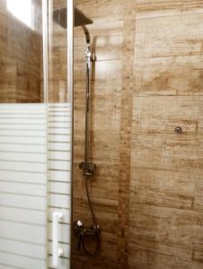 a shower in a bathroom with a wooden wall at Precioso apartamento 3 habitaciones. Con patio. in Camas