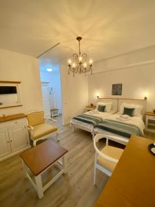 1 dormitorio con 2 camas y lámpara de araña en Pensiunea Charlotte Boutique en Bacău