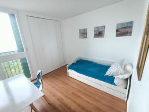 a small white room with a bed and a table at VUE MER et montagne dans parc du roy d'espagne, Up to 7 people in Marseille