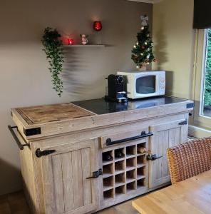 a microwave on top of a wooden cabinet with a wine cellar at Vakantiehuis 6 pers, Oostduinkerke aan zee in Koksijde