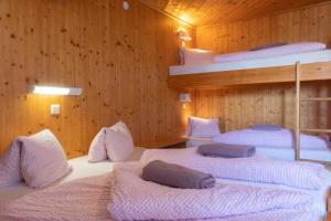 a room with three bunk beds in a wooden wall at Skihütte Zams in Zams