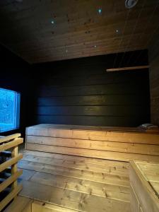 a room with a wooden floor and a black wall at Kiiski Home in Teijo