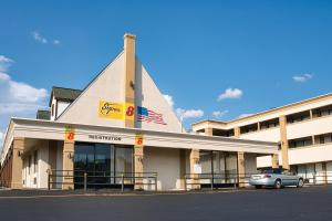 a building with a car parked in front of it at Super 8 by Wyndham WestEnd Alexandria,VA Washington DC Area in Alexandria