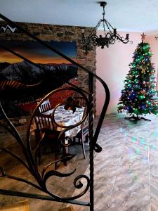 a christmas tree in a room with a chair and a fireplace at Pokoje Gościnne Skalne Podhale in Bukowina Tatrzańska