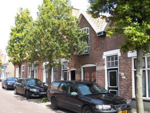 a black car parked in front of a brick building at House@Domburg in Domburg