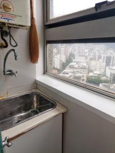 cocina con fregadero y ventana en Maravilhoso flat no Leblon, en Río de Janeiro