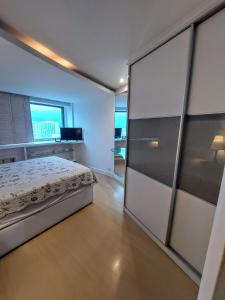 1 dormitorio con 1 cama y puerta corredera de cristal en Maravilhoso flat no Leblon, en Río de Janeiro