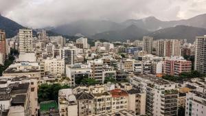 una ciudad con edificios y montañas en el fondo en Maravilhoso flat no Leblon, en Río de Janeiro