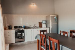 a kitchen with a table and a refrigerator at El Pedregal Cabaña rural 2 dorm Hasta 6 personas in Cafayate