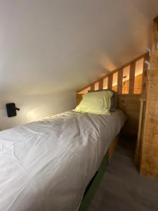 Bett mit einem Kopfteil aus Holz in einem Zimmer in der Unterkunft Genepi loft duplex 4 personnes in Arâches-la-Frasse