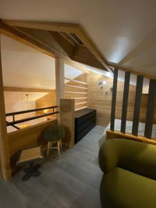 a living room with a green couch and a desk at Genepi loft duplex 4 personnes in Arâches-la-Frasse
