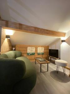 a living room with a green couch and a table at Genepi loft duplex 4 personnes in Arâches-la-Frasse