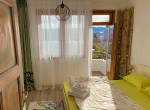 a bedroom with a bed and a window with a view at Guest house Hei Taka in Sozopol