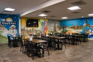 uma sala de jantar com mesas e cadeiras e um mural em Days Inn by Wyndham WestEnd Alexandria,VA Washington DC Area em Alexandria