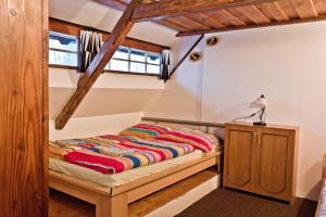 a bedroom with a bed with colorful blankets on it at Penzion pod Železným Vrchem in Chřibská