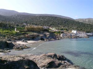 - une vue sur une plage avec des rochers dans l'eau dans l'établissement Traditional stone-built cottages Azalas, à Moutsoúna