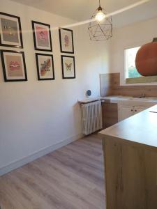 a kitchen with a counter and pictures on the wall at La marMotte perchée in Gap