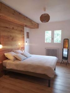 a bedroom with a large bed with a wooden wall at La marMotte perchée in Gap