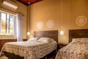 una camera da letto con due letti e una finestra di Pousada Lua Luana a Cambuquira