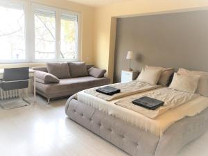 a bedroom with a large bed and a couch at Brand new apartment in the center in Budapest