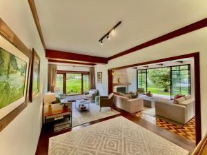 a living room filled with furniture and a large window at Casa Três Rios - Campos do Jordão in Campos do Jordão