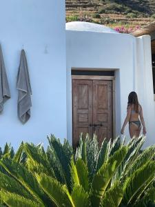 Una donna in bikini che esce da una porta di Dammuso dei Turchi by the ocean a Tracino