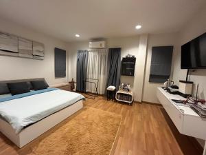 a bedroom with a bed and a desk with a television at Autta house in Ban Lat Tanot