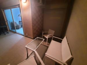 - deux chaises blanches dans une chambre avec porte dans l'établissement Luna Reale Relais, à San Nicola La Strada