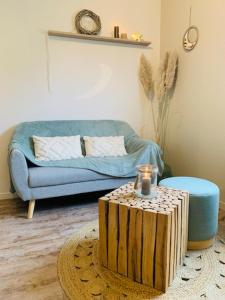 a living room with a blue couch and a table with a wooden stump at La petite halte in Lemberg