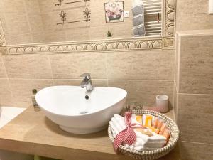 La salle de bains est pourvue d'un lavabo et d'un panier de serviettes. dans l'établissement Sweet Garden Residence, à Braşov