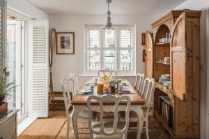 a dining room with a wooden table and chairs at Half Moon in Camber