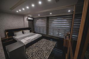 sypialnia z łóżkiem i dużym oknem w obiekcie Hotel Premium w Prisztinie