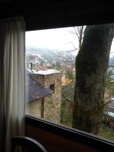 ventana con vistas a un edificio de piedra en Altos del Alma Cabañas en San Martín de los Andes