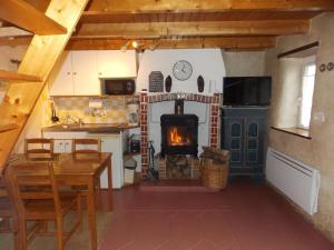 cocina con chimenea, mesa y fogones en Gîte Ty Bihan Baradoz, en Scrignac