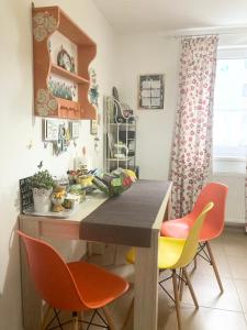 a kitchen with orange and yellow chairs and a table at Sweet Butterflies Residence in Braşov