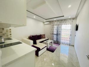 Sala de estar blanca con sofá y mesa en Queen Kodre Apartments, en Ulcinj