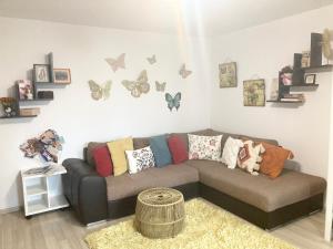 a living room with a couch and butterflies on the wall at Sweet Butterflies Residence in Braşov