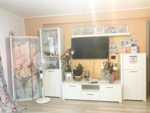 - un salon avec un centre de divertissement blanc et une télévision à écran plat dans l'établissement Sweet Butterflies Residence, à Braşov