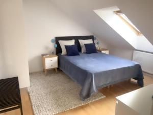 una camera da letto con letto blu in mansarda di Velindrettet rækkehus med fantastisk udsigt a Næstved