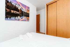 1 dormitorio con 1 cama y una pintura en la pared en EDELWEISS - El Pueyo, 5 pax y Wifi en El Pueyo de Jaca