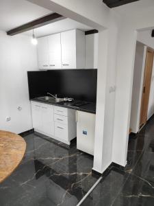 a white kitchen with a sink and a table at Fenix 1 in Belgrade