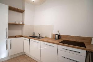 ボレーヌにあるAppartement 55m² - 2/4 personnes en centre villeの白いキャビネットとシンクのあるキッチン