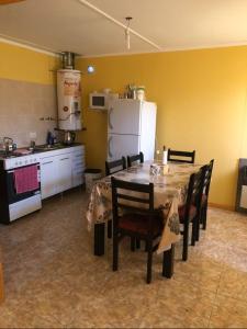 Il comprend une cuisine équipée d'une table, de chaises et d'un réfrigérateur. dans l'établissement Cba, à El Calafate