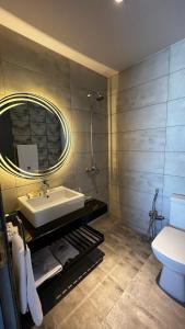 La salle de bains est pourvue d'un lavabo, d'un miroir et de toilettes. dans l'établissement VivaPines, Murree, à Murree